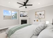 Thumbnail 6 of 19 - Carpeted bedroom with ceiling fan and private fireplace.