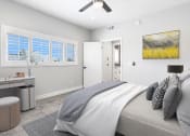 Thumbnail 4 of 22 - Carpeted bedroom with ceiling fan and large windows for natural light.