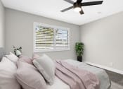 Thumbnail 8 of 23 - Carpeted bedroom with ceiling fan and large windows.