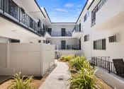 Thumbnail 14 of 24 - Green outdoor courtyard depicting access to walk-up units.