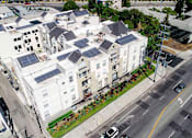 Thumbnail 24 of 24 - Aerial drone image off Palms Blvd showing solar panels and white roof.