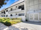 Thumbnail 21 of 24 - Entrance to National Apartments with drought-resistant greenery.