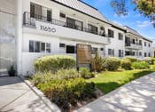 Thumbnail 20 of 24 - Entrance to National Apartments with drought-resistant greenery.