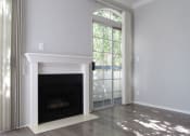 Thumbnail 11 of 20 - Fireplace with overhanging mantle and large windows with patio access.