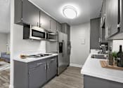 Thumbnail 2 of 18 - Spacious kitchen with stainless steel fridge, oven, and microwave.