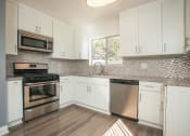 Thumbnail 10 of 24 - Large kitchen with new cabinets, stainless steel appliances, quartz stone counters, and modern backsplash.