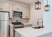 Thumbnail 2 of 23 - Kitchen with new modern styled faucet, stainless steel appliances, and refrigerator.