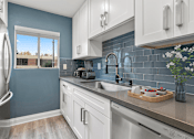 Thumbnail 3 of 31 - Blue tiled kitchen with stainless steel fridge and dish washer.