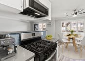 Thumbnail 1 of 24 - Blue tiled kitchen with stainless steel oven and microwave and view of hardwood floor dining room.