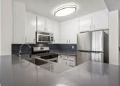 Thumbnail 2 of 15 - Kitchen with stainless steel oven, microwave, and fridge.