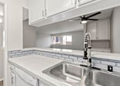 Thumbnail 2 of 22 - White tiled kitchen with stainless steel farmhouse style sink.