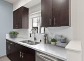 Thumbnail 9 of 22 - White tile kitchen with granite countertop and stainless steel fridge, oven, and fixtures.