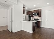 Thumbnail 7 of 23 - Tiled kitchen with stained wood cabinets and stainless steel appliances.
