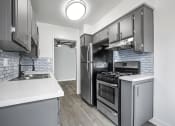 Thumbnail 12 of 28 - Tiled kitchen with stainless steel oven, fridge, and fixtures.