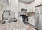 Thumbnail 15 of 27 - Kitchen with stainless steel fridge, oven, and microwave.