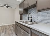 Thumbnail 13 of 28 - Tiled kitchen with stainless steel sink, microwave, and fridge.