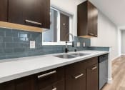 Thumbnail 6 of 22 - Blue tiled kitchen with stainless steel dishwasher.