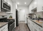 Thumbnail 13 of 29 - Brand new kitchen cabinets, back splash, quartz stone counter tops, and stainless steel appliances with fridge!