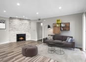 Thumbnail 3 of 29 - Living room with decorative stone wall, fireplace, and hardwood floors.