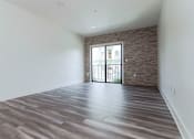 Thumbnail 16 of 23 - Living room with stone accent wall and view of balcony.