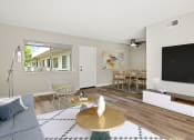 Thumbnail 8 of 28 - Hardwood floored living room with view of courtyard and dining room.
