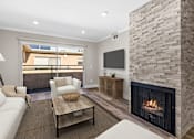 Thumbnail 1 of 31 - Living room with stone accented fireplace and balcony access.