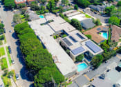 Thumbnail 23 of 24 - Aerial drone view of National Apartments depicting roof-mounted solar panels and adjacency to Whole Foods Market.