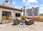 Thumbnail 10 of 23 - Open air rooftop patio with gas firepit, BBQs, several seating locations, and cable television.