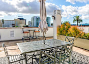 Thumbnail 9 of 23 - Open air rooftop patio with gas firepit, BBQs, several seating locations, and cable television.