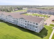 Thumbnail 17 of 23 - A large white building with a green lawn in front.