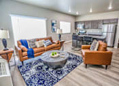 Thumbnail 7 of 23 - A living room with a brown couch and a blue rug.