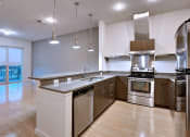 Thumbnail 29 of 35 - Beautiful apartment kitchen with stainless steel appliances and granite counters and bar at The Mosaic on Broadway, San Antonio, 78215