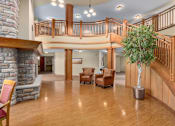 Thumbnail 13 of 50 - A living room with a stone fireplace and wooden floors.