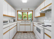 Thumbnail 16 of 27 - A kitchen with white cabinets and a window.