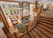 Thumbnail 7 of 50 - A large, well-lit living room with a staircase leading to the upper floor.