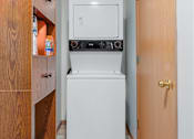 Thumbnail 20 of 27 - A small kitchen with a white dishwasher and a microwave above it.