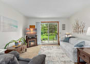 Thumbnail 22 of 27 - A cozy bedroom with a fireplace and a view of the backyard.