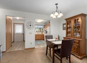 Thumbnail 24 of 27 - A dining room with a wooden table and chairs.
