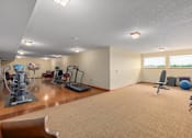 Thumbnail 16 of 50 - A spacious room with exercise equipment and a large window.