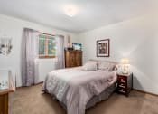 Thumbnail 26 of 27 - A bedroom with a bed, nightstand, and window.