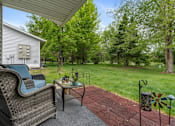 Thumbnail 4 of 27 - A patio with a chair and table is shown.