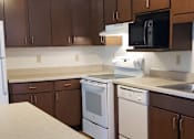 Thumbnail 6 of 6 - an empty kitchen with white appliances and wooden cabinets