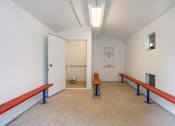 Thumbnail 9 of 27 - A room with a bench and a door.