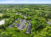 Thumbnail 10 of 27 - A bird's eye view of a parking lot surrounded by trees.