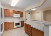 Thumbnail 28 of 50 - A kitchen with wooden cabinets and a white fridge.