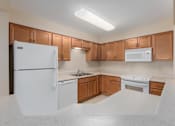 Thumbnail 27 of 50 - A kitchen with white appliances and wooden cabinets.