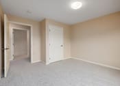Thumbnail 32 of 50 - A room with a carpeted floor and two doors.