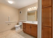 Thumbnail 35 of 50 - A bathroom with a toilet, sink, and a mirror.