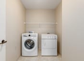 Thumbnail 36 of 50 - A white washing machine and dryer in a small laundry room.