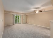 Thumbnail 38 of 50 - A spacious room with a ceiling fan and sliding glass doors.